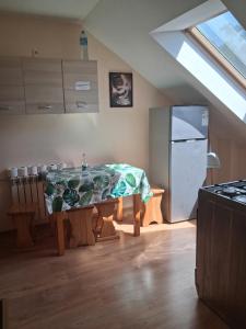 a kitchen with a table and a refrigerator at Agroturystyka Pod Brzozami in Susiec