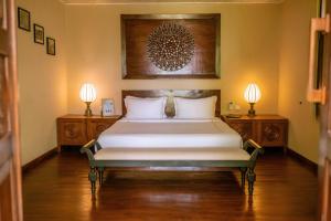a bedroom with a bed with two night stands and two lamps at Aga Surf View in Tangalle