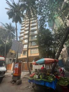 a fruit stand with an umbrella in front of a building at Modern 2bed Bandra AreaParkingUnit 2 in Mumbai