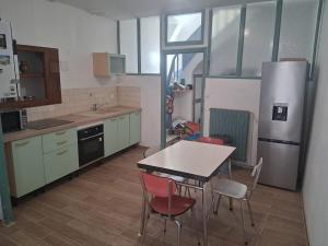 a kitchen with a table and chairs and a refrigerator at Maison T3 - Hypercentre historique - WIFI in Villefranche-de-Rouergue +13 photos