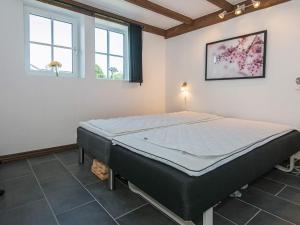 a bedroom with a bed in a room with windows at 5 star holiday home in Ansager in Ansager