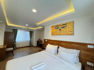 a hotel room with a bed and a painting on the wall at Hotel Harsha Nepal in Kathmandu +37 photos