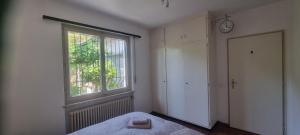 a bedroom with a bed and a window and a door at Doppelzimmer mit Gemeinschaftsbad - und Küche in Purasca
