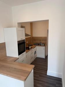 a kitchen with white cabinets and a stove top oven at 3 Russell street, Flat 2 in Gloucestershire