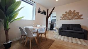 a living room with a table and a couch at Le Citadel - Centre et Quais in Dunkerque