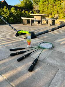 four tennis rackets on the ground with a drink at Őzike Vendégház - Tiszakécske in Tiszakécske