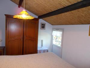 - une chambre avec un lit, une armoire en bois et une fenêtre dans l'établissement Le journal Blanc, à Notre-Dame-de-Monts