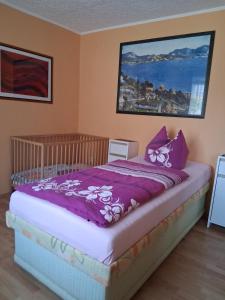 a bedroom with a bed with a purple comforter at Ferienhaus Harzidylle in Siptenfelde