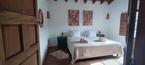 a bedroom with a white bed with shoes on it at Cortijo J&S Juan Salvador in Málaga +125 photos