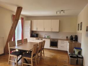 a kitchen with a wooden table and chairs in a room at Ferienwohnungen Meyer in Heilsbronn
