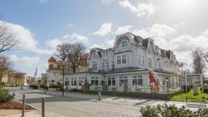 a large white building on the side of a street at Villa Strandperle IV Jahreszeiten Kühlungsborn in Kühlungsborn