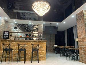a restaurant with a bar with chairs and a chandelier at Villa Oranji in Itʼkhvisi