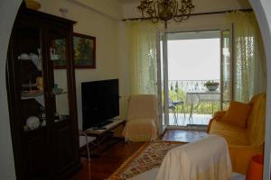 a living room with a couch and a television at Katoussa in Paleokastritsa