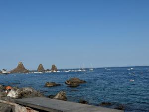 un cuerpo de agua con rocas y barcos en él en Almarèa, a un passo dal mare, en Aci Castello