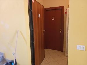 White Coral Rooms self check-in في ألغيرو: ممر به باب بني اللون عليه الرقم اثنين