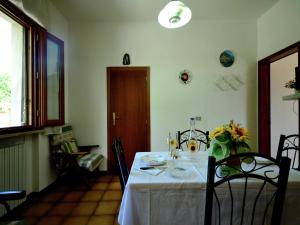 a dining room table with a white table cloth and flowers on it at Sunlit home with pool in Fucecchio +31 photos