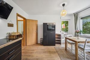 eine Küche mit einem schwarzen Kühlschrank und einem Tisch in der Unterkunft Royal Garden Residence in Dresden + 10 Fotos