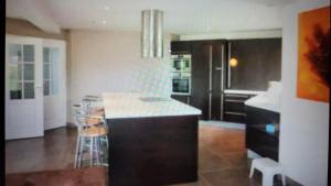 - une cuisine avec un îlot au milieu d'une pièce dans l'établissement Villa moderne à 200m de la mer avec jardin clos, à Saint-Vaast-la-Hougue