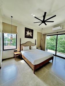 a bedroom with a bed and a ceiling fan at The Soul Stones Villas in Vagator