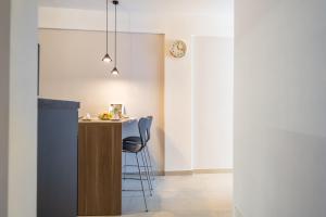 a kitchen with a counter and a bar with chairs at Centoquaranta Apartment in Terrasini +42 photos