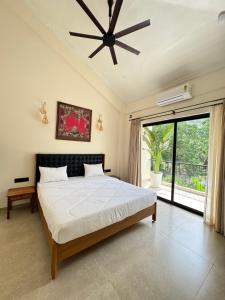 a bedroom with a bed and a ceiling fan at The Soul Stones Villas in Vagator