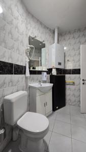 een witte badkamer met een toilet en een wastafel bij Sleep and Enjoy in Brussel