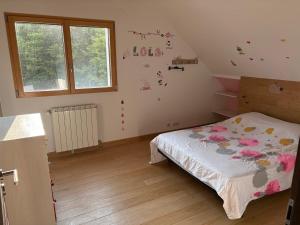 - une chambre avec un lit orné de fleurs sur le mur dans l'établissement Le Cocon des Volcans d'Auvergne, à La Chapelle-dʼAlagnon