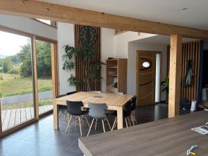 une salle à manger avec une table et des chaises en bois dans l'établissement Le Cocon des Volcans d'Auvergne, à La Chapelle-dʼAlagnon