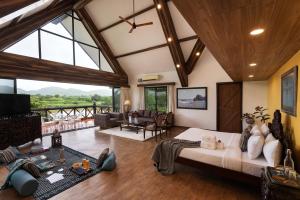 JāmbにあるSaffronStays Cabin in the Woodsの大きなベッドと大きな窓のある広いリビングルーム