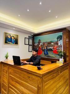 a man sitting at a desk with a laptop at Hotel Harsha Nepal in Kathmandu