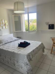 a white bedroom with a bed with a window at Maison 6 pers. A 5 mn du lac in Montauroux