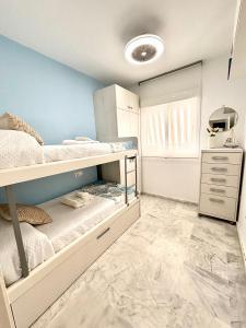 a bedroom with two bunk beds and a blue wall at Apartamento Atlántico in Rota