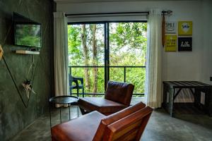 a living room with a chair and a large window at Area 4 eco cubes in Ella