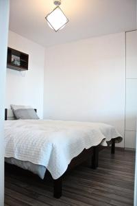 メヘリンキにあるApartament Mechelinkiのベッドルーム1室(白い毛布付きのベッド1台付)