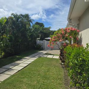 a garden with pink flowers next to a house at Villa in Sunset Crest, Holetown in Saint James