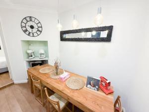a dining room table with chairs and a clock on the wall at Sydney Dawes point 4bed cls Sydney Harbour bridge in Sydney
