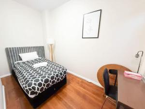 a bedroom with a bed and a desk and a chair at Sydney Dawes point 4bed cls Sydney Harbour bridge in Sydney