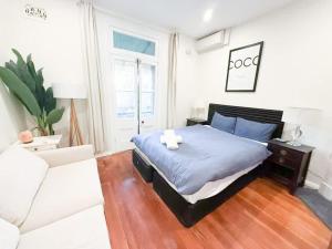 a bedroom with a bed and a white couch at Sydney Dawes point 4bed cls Sydney Harbour bridge in Sydney +7 photos