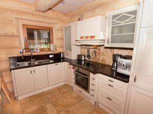 a kitchen with white cabinets and a sink at Family log cabin in the Alps in Ruhpolding +32 photos