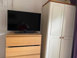 a flat screen tv sitting on top of a wooden dresser at Woodstock in York