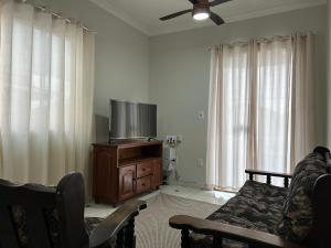 リオ・ダス・オストラスにあるApartamento sala e quarto com ar na Praia do Abricóのリビングルーム(テレビ、ソファ付)