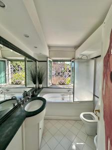 a bathroom with a tub and a sink and a toilet at Penthouse Luxe - Rome in Rome
