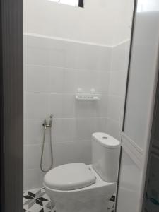 une salle de bain blanche avec toilettes et douche dans l'établissement Aqilla Homestay Besut, à Kampung Kuala Besut