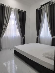 - un lit avec des rideaux noirs dans une chambre dans l'établissement Aqilla Homestay Besut, à Kampung Kuala Besut 6 autres photos