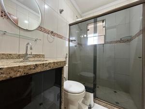 リオ・ダス・オストラスにあるApartamento sala e quarto com ar na Praia do Abricóのトイレとガラスのシャワー付きのバスルーム +28枚の写真