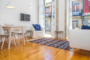 a living room with a table and chairs and a table at Liiiving in Porto | Blue Flower Apartment in Porto