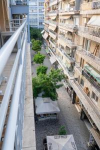 a balcony view of a building with tables and trees at Central Thessaloniki Boutique in Thessaloniki