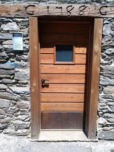 a wooden door on a stone building at VERO RUSTICO ALPiNO in Madesimo +45 photos