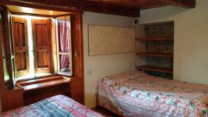 a bedroom with two beds and a window at VERO RUSTICO ALPiNO in Madesimo