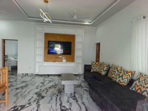 Una sala de estar con un sofá y un televisor de pantalla plana. en Diani Dream luxury apartment, en Diani Beach